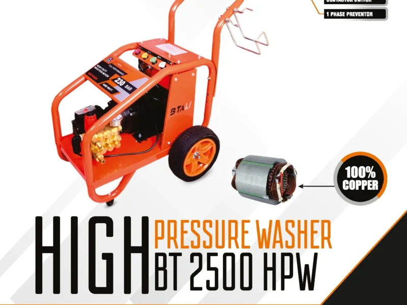 A professional heavy duty commercial pressure washer being used on an Indian construction site to clean large machinery.
