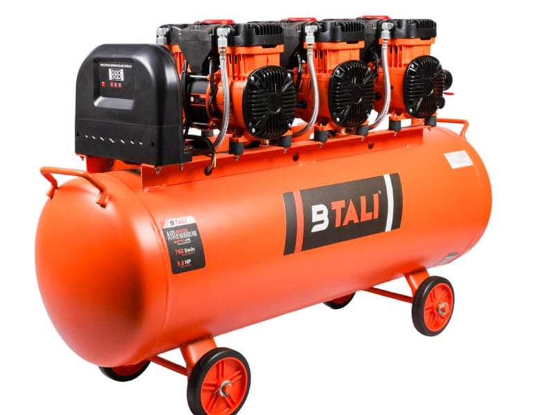A technician performing professional air compressor maintenance on a high pressure industrial air compressor in India.