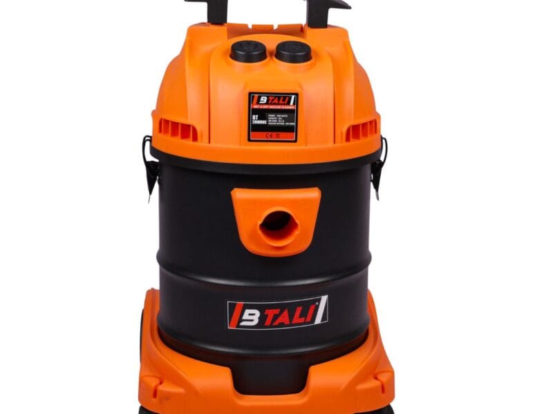 Professional cordless vacuum cleaner being used for rapid car detailing services in an Indian automotive workshop.